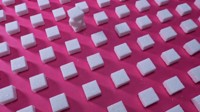 图案方糖在粉红色的背景上，在镜头平移视频素材