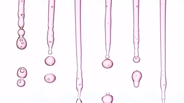 近距离和缓慢的运动，下降水晶清晰淡粉色水滴无缝垂直模式，对白色的背景视频素材