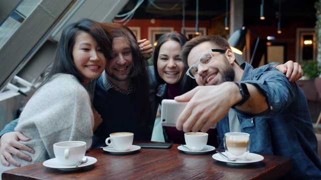 多民族的朋友在咖啡馆用智能手机自拍视频下载