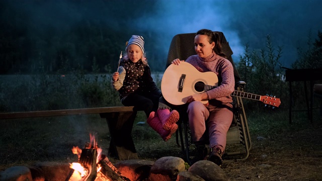 小女孩和妈妈在篝火旁放松视频素材