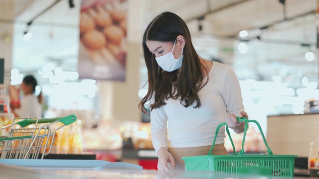戴口罩的女人在超市选购冷冻产品视频素材