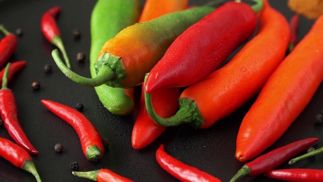 把新鲜的胡椒粉放在托盘上，用水滴旋转。辣椒，红辣椒，辣椒，花椒。用香料烹饪食物的概念视频下载