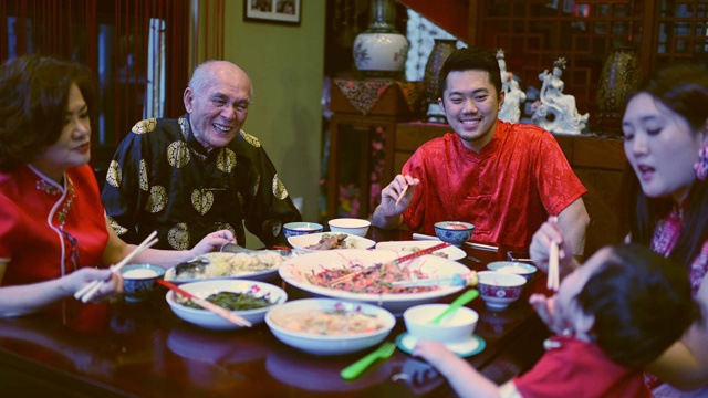 亚洲华人家庭春节团圆饭吃传统菜肴生鱼刘生视频素材