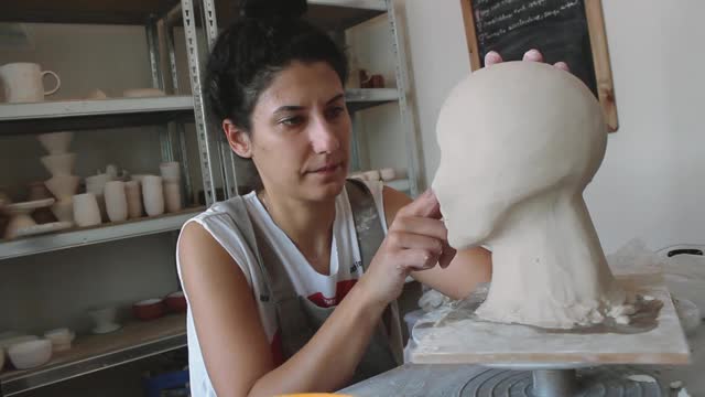 女艺术家在她的工作室里做雕塑视频下载