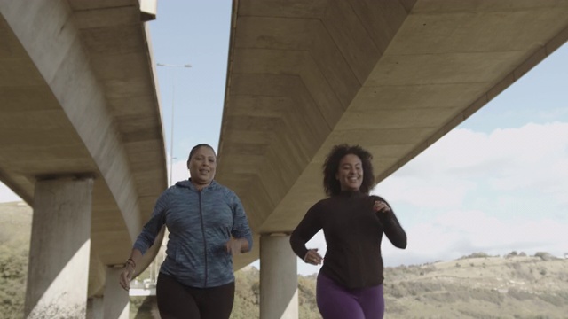两名大码女性在城市桥下户外慢跑锻炼，肥胖黑人女性运动锻炼身体积极视频素材