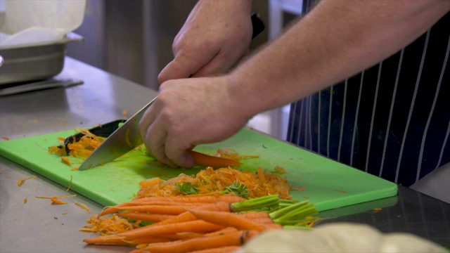 厨师在餐厅厨房削胡萝卜视频素材