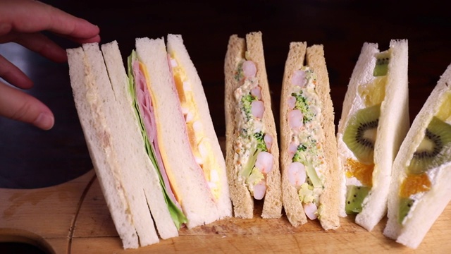 手拿起一个日本便利店的三明治，从右向左移动视频下载