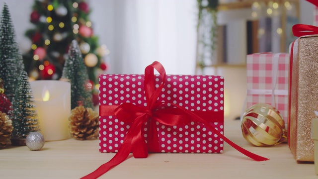 圣诞树和新年礼盒装饰装饰在家里的木桌上。礼物和祝贺的背景概念。4 k慢动作。放大拍摄。视频下载