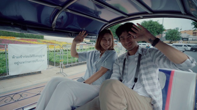年轻英俊的男子戴着帽子和他的女朋友骑在传统的嘟嘟夫妇旅行泰国在他们的蜜月视频素材