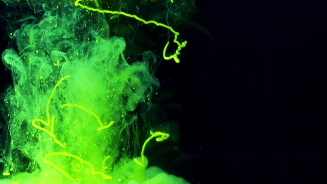 荧光绿色油墨在水中流动并形成形状视频下载