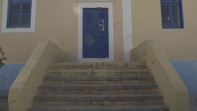 希腊塞米岛——2020年9月25日:倾斜拍摄的彩色政府大楼入口，该岛的主题是港口附近的中世纪教堂。不分级/平坦的艰苦剖面。视频下载