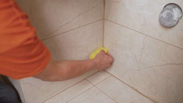 用软布擦拭浴室瓷砖。一名工人用抹布擦拭浴室的瓷砖。视频素材