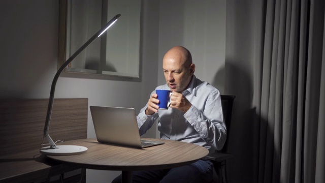 商务白领，自由职业者，晚上在家工作到很晚，带着笔记本电脑。喝水或咖啡。视频素材