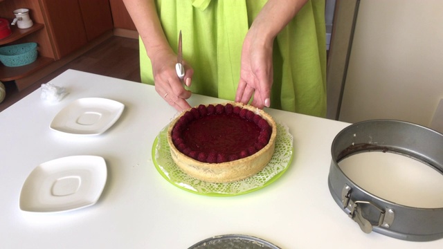 这个女人把莱文顿的蛋糕从模子里拿了出来。用树莓装饰的蛋糕视频素材