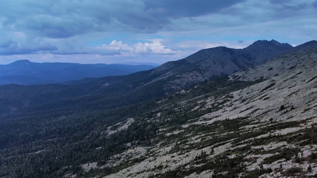 从飞行无人机鸟瞰图上的山地森林背景和蓝色山脉的顶峰。视频素材