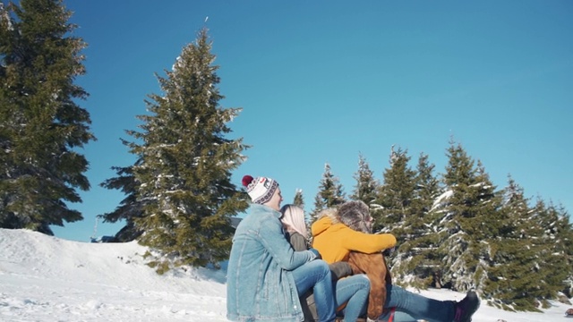 年轻人微笑着一起从雪山上滑下来玩得开心的慢镜头视频素材