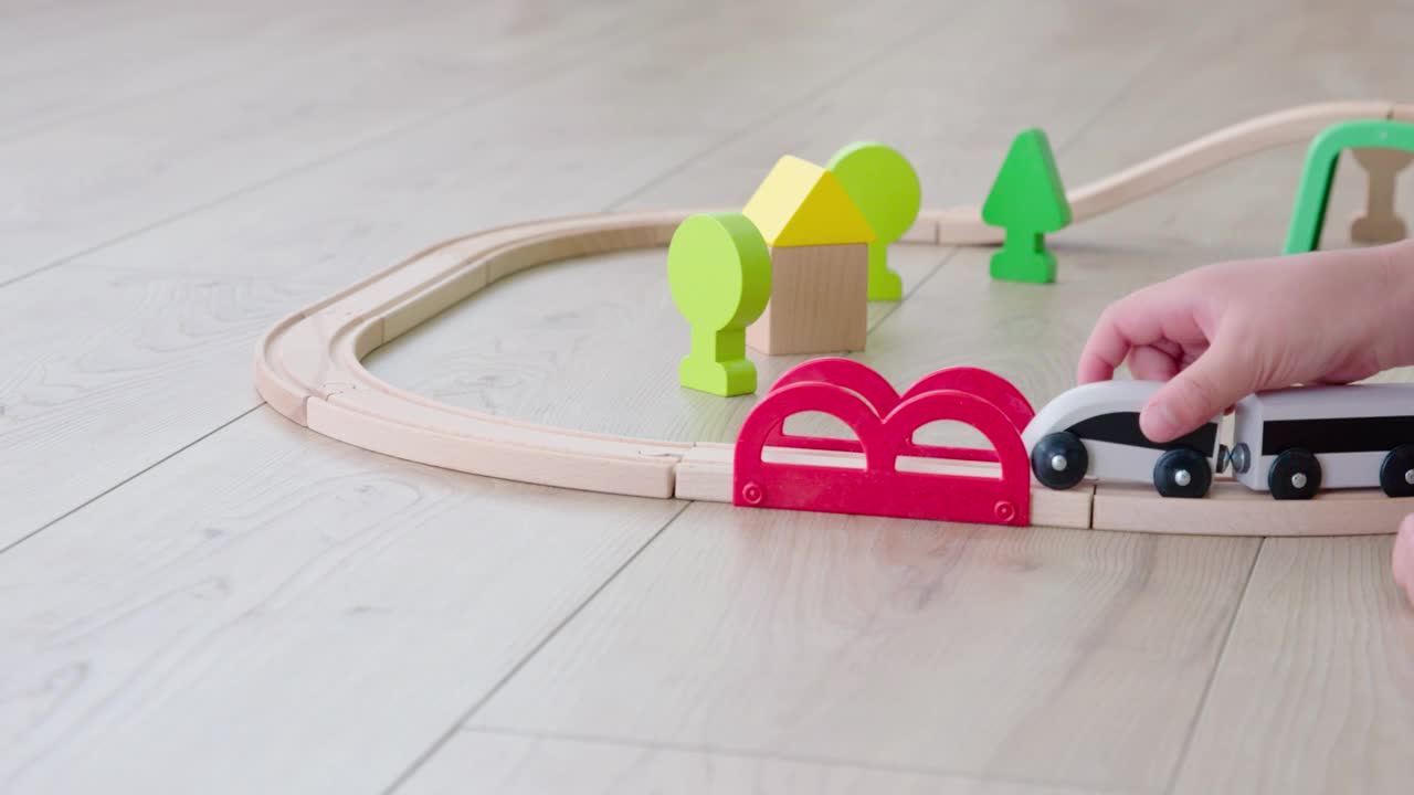 快乐的小男孩在地板上玩玩具火车，4K视频素材