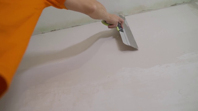 手用油灰刀修墙，手用刮刀，刮刀用结构抹墙膏，涂层过程用油灰镘刀，用工作抹墙膏视频素材