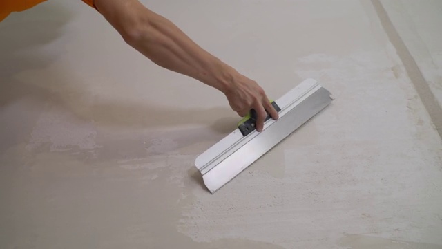手用油灰刀修墙，手用刮刀，刮刀用结构抹墙膏，涂层过程用油灰镘刀，用工作抹墙膏视频素材