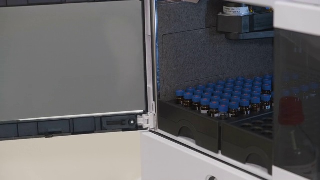 分析化学家带小瓶进入高效液相色谱系统的自动进样器。视频下载