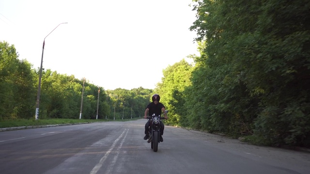 摩托车手在乡村公路上飞驰，咖啡车手摩托车冒险生活方式视频素材
