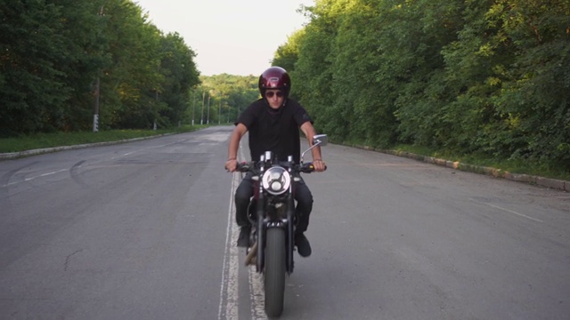 摩托车手在乡村公路上飞驰，咖啡车手摩托车冒险生活方式视频素材