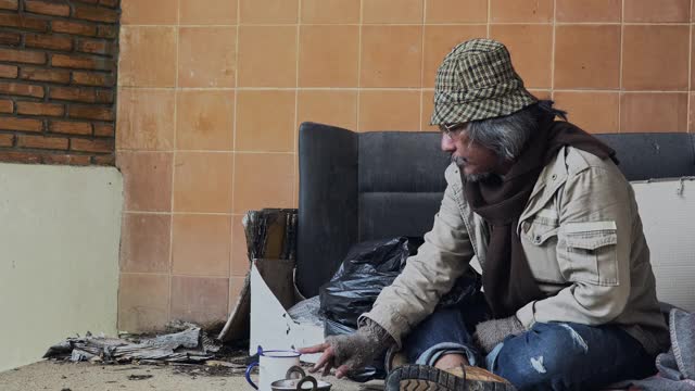 一个无家可归的人坐在街上。城市概念中无家可归者的问题。视频下载
