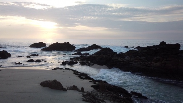 日出时海浪拍打着岩石视频下载
