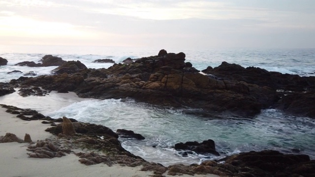 日出时海浪拍打着岩石视频下载