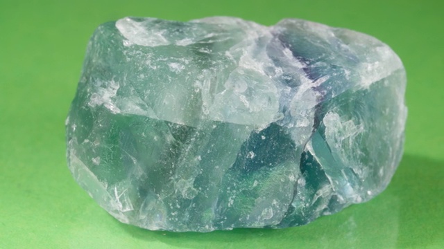 绿色背景上的矿物萤石。一个浮动的圆木特写的观点。视频下载