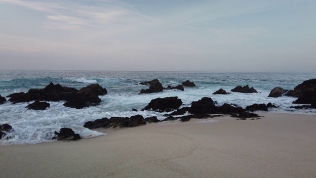 日出时海浪拍打着海岸。视频下载