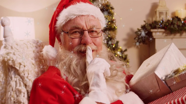 雪花落在圣诞老人手里，手指放在嘴唇上，拿着礼物视频下载