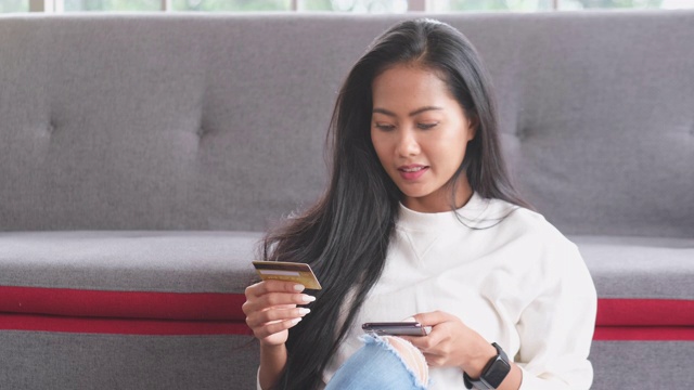 年轻的亚洲女人用信用卡在手机上购物，慢镜头，4K分辨率视频素材