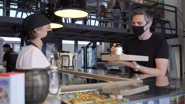 顾客正在给手消毒，在披萨店取外卖视频素材