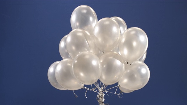 装饰元素的生日或圣诞节，抱着气球上升，起飞，在蓝色的背景。视频下载