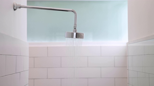 打开浴室的淋浴喷头，水从淋浴间倾泻而出。视频素材
