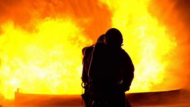 男性消防员用消防水龙带灭火视频素材
