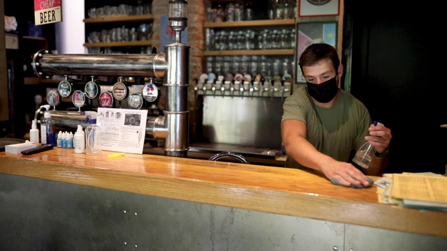 服务员在开啤酒厂前使用消毒产品清洁吧台视频素材
