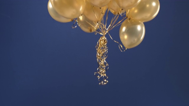 一个装饰元素——金色气球——出现在视频中，以蓝色背景作为情人节、生日、圣诞节或新年的惊喜。视频素材