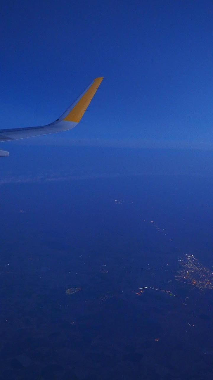 飞机在夜间飞行，从飞机窗口看云和蓝天。视频素材