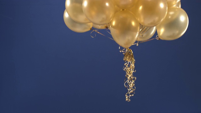 一个装饰元素-金色气球-出现在视频中作为礼物情人节，生日，圣诞节或新年在Chroma钥匙。视频素材