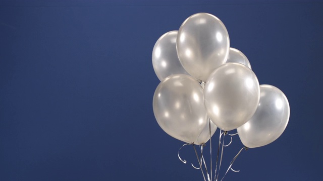 装饰元素——气球——飞进视频的相框，作为节日的惊喜:在蓝色背景上的情人节、生日、圣诞节或新年。视频下载