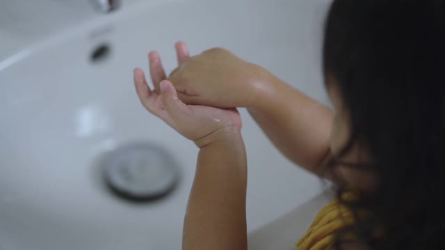 小女孩在室内洗手以防止病毒和细菌。视频素材