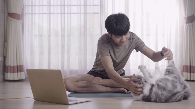 一个年轻人在他的房子里玩猫视频素材