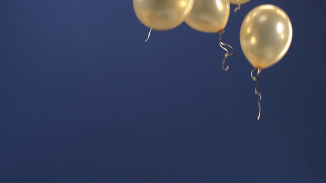 节日装饰-气球-在视频中飞起来作为一个节日的惊喜:情人节，生日，圣诞节，一个节日活动或新年在蓝色的背景。视频素材