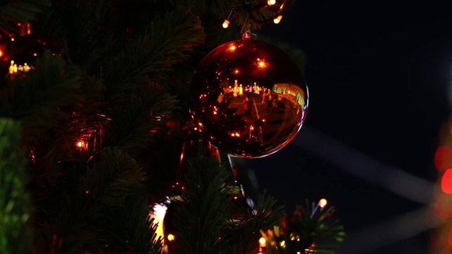 圣诞玩具在松枝上的背景下闪闪发光的圣诞灯视频素材