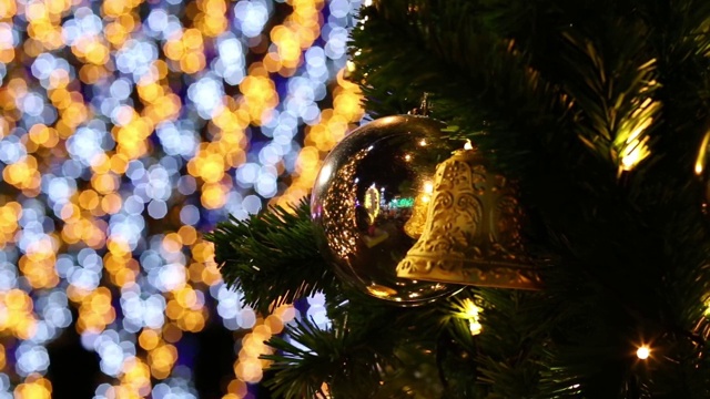 圣诞钟和玻璃球在云杉树枝上的背景新年的照明视频素材
