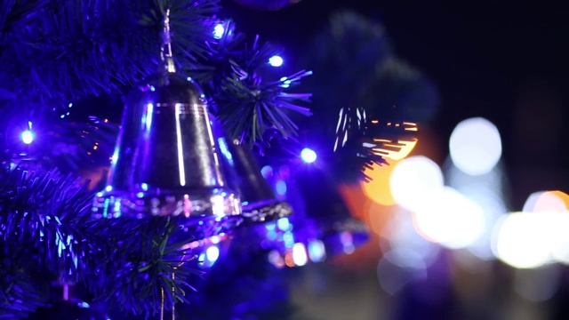 圣诞树上的圣诞钟声映衬着闪闪发光的彩灯视频素材