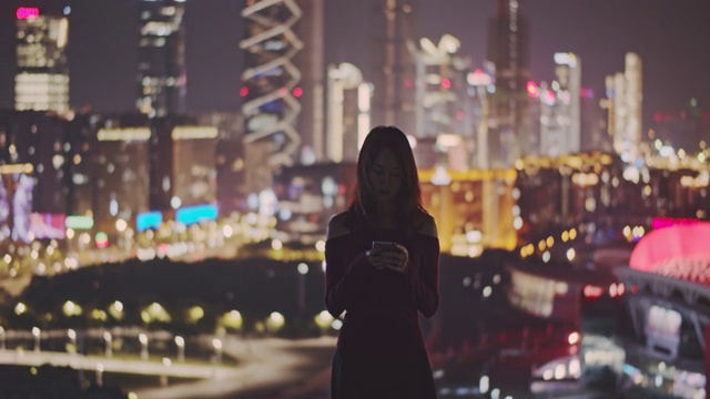 一名年轻女子在城市屋顶上使用手机视频素材