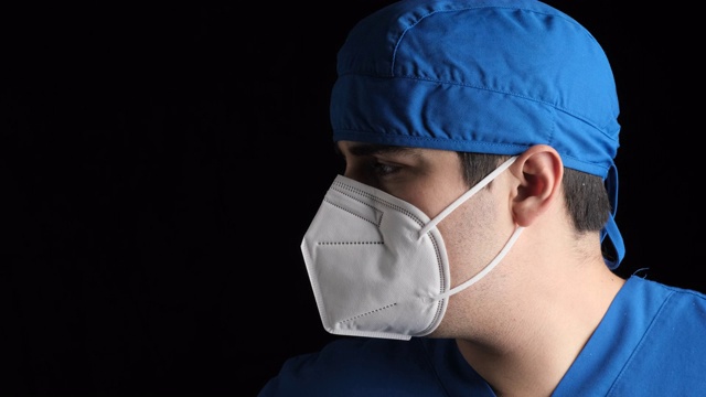 沉思疲倦的年轻男性医疗工作者戴着n95防护面罩看着摄像机视频素材